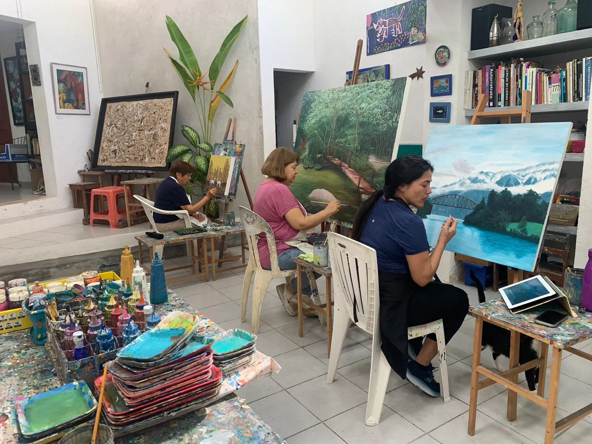 Adult students painting at easels in the workshop