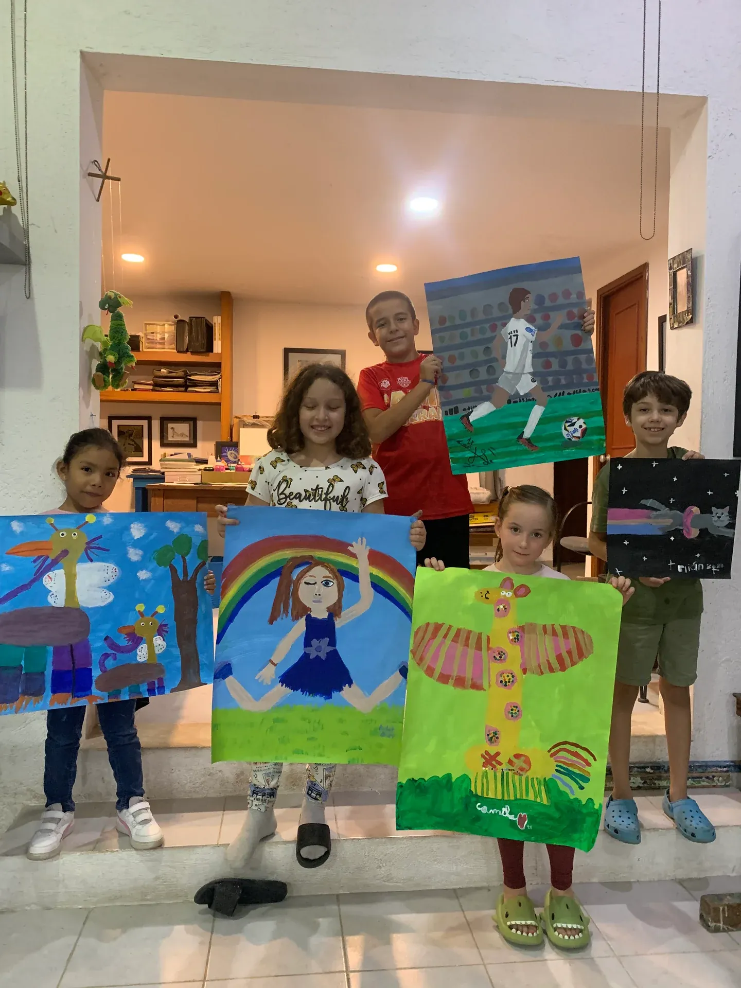 Children proudly showing their finished paintings