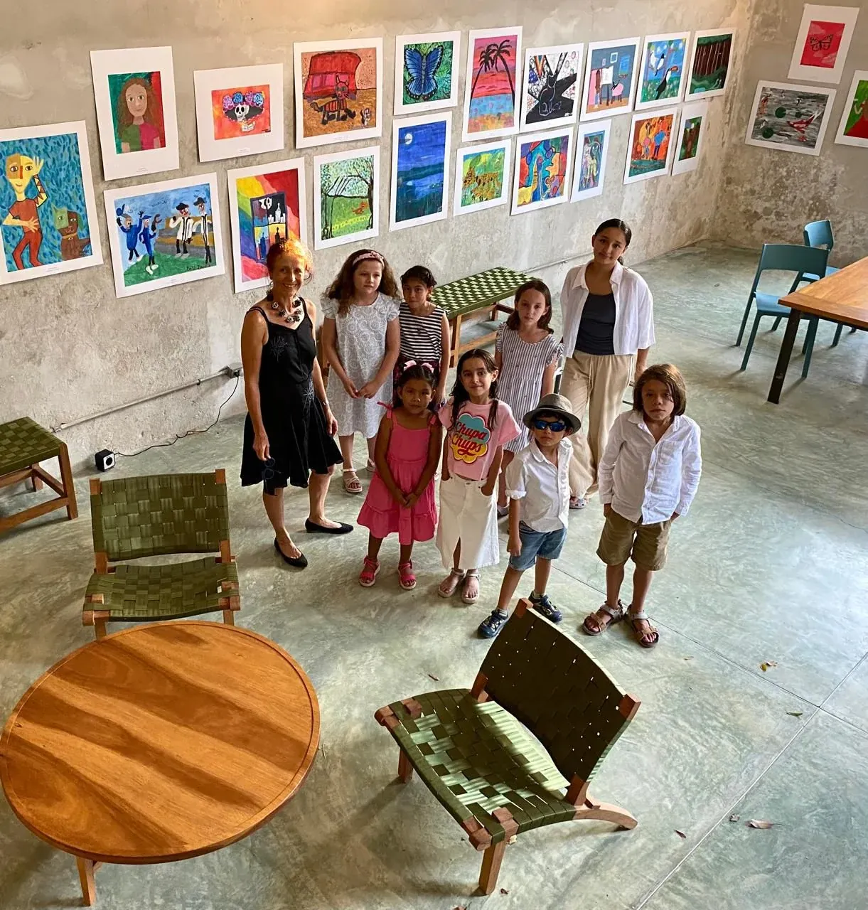 Group of students posing with their artwork on the wall